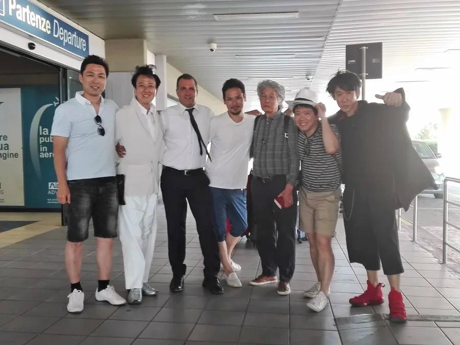 Eine Gruppe vor dem Eingang zum Abflugbereich eines Flughafens, am Ende der Reise