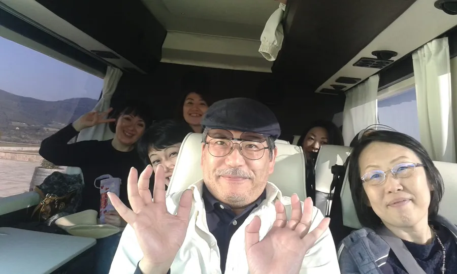 Un gruppo sorridente seduto a bordo di un minibus