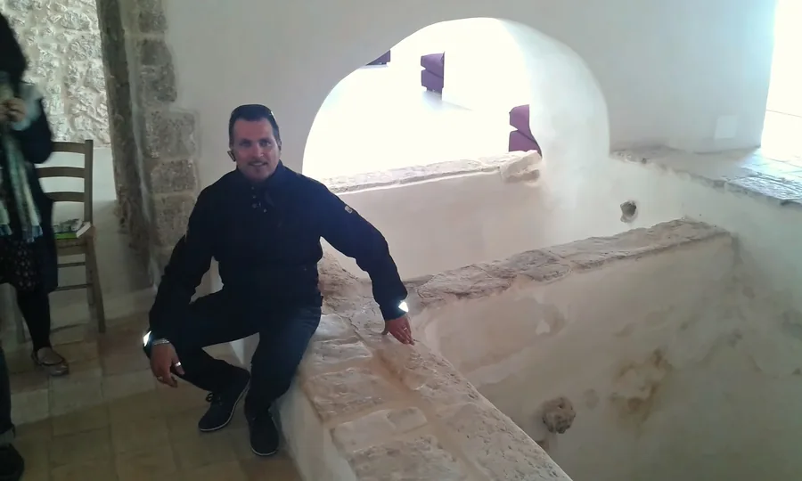 Der Besuch im Weinkeller, zwischen Steinbecken unter einem weißen Bogen