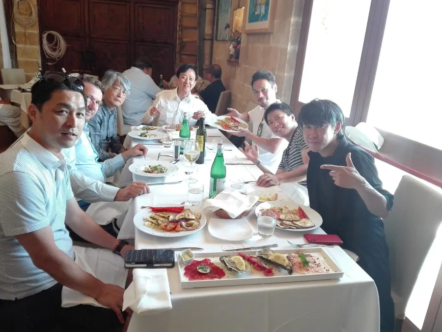 Un gruppo a tavola in un ristorante, con i piatti di pesce