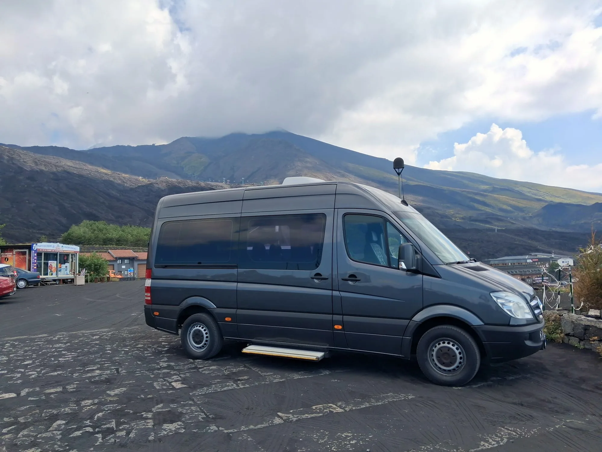 Il Mercedes-Benz Sprinter grigio scuro di Exclusive Journeys sull'Etna, con la pedana elettrica aperta