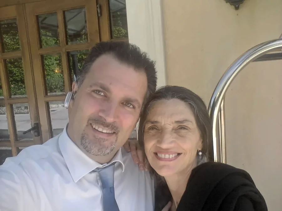 El chófer y una invitada sonrientes, delante de una puerta de cristal