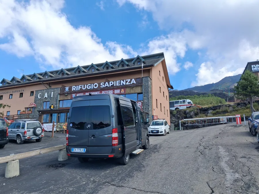 Lo Sprinter grigio scuro visto da dietro, con la porta laterale aperta e la pedana, davanti al Rifugio Sapienza sull'Etna